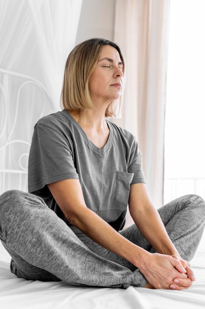 Full shot woman sitting with closed eyes