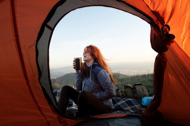 飲み物と一緒に座っているフルショットの女性