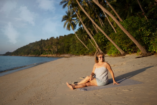 Foto gratuita donna a figura intera che trascorre una giornata da sola sulla spiaggia