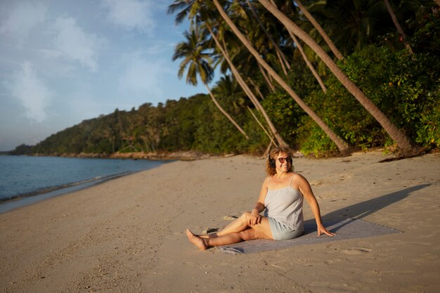 Full shot woman spending a day alone on the beach