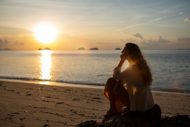 Full shot woman spending a day alone on the beach