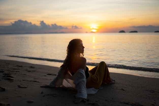 Free photo full shot woman spending a day alone on the beach