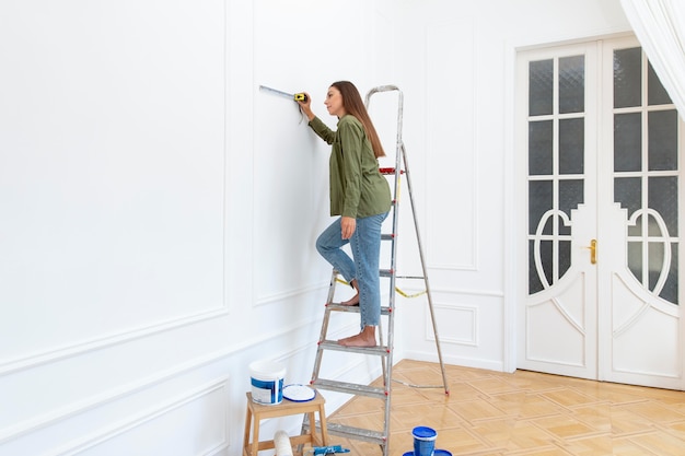 Full shot woman standing on ladder