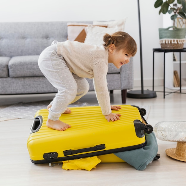 Full shot woman standing on luggage