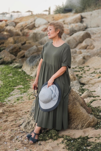 Free photo full shot woman standing near rock