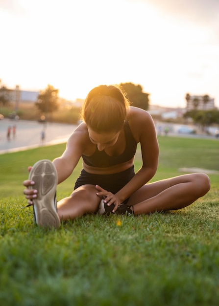 Free photo full shot woman stretching on grass