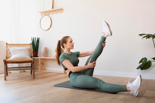 Free photo full shot woman stretching leg