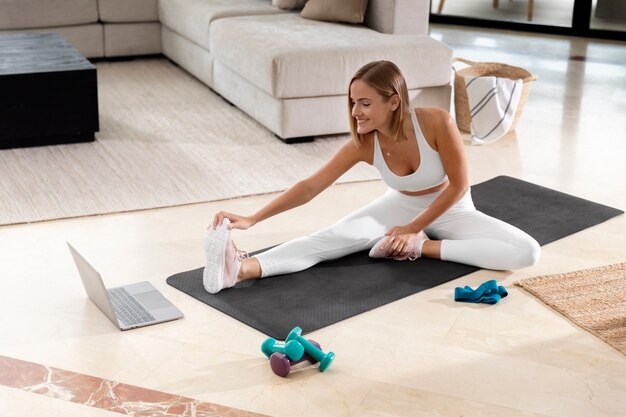 Full shot woman stretching leg