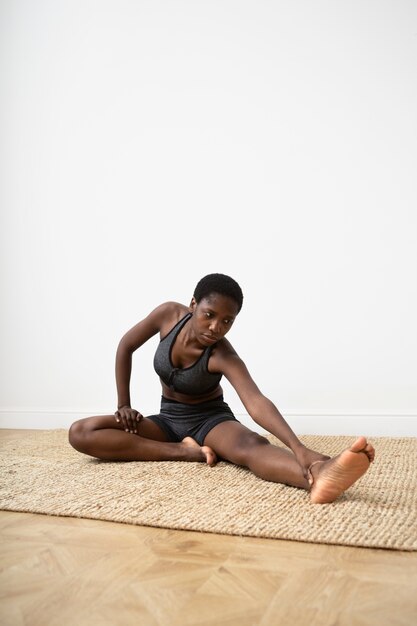 Full shot woman stretching  leg