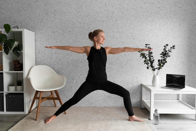 Full shot woman stretching in living room