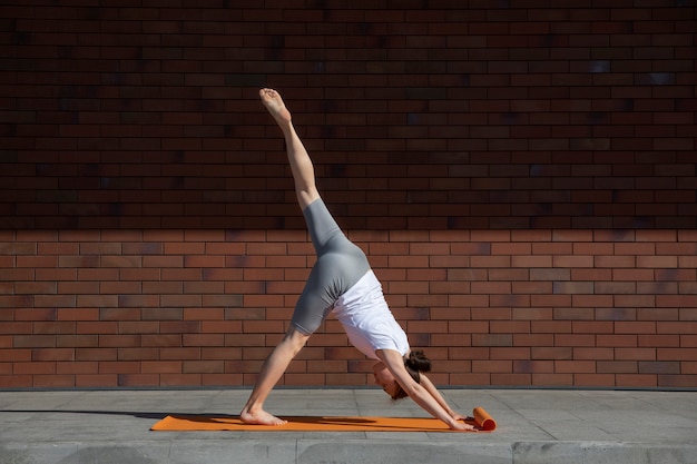 Free photo full shot woman stretching on mat