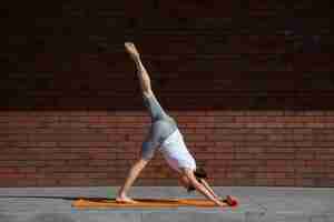 Free photo full shot woman stretching on mat