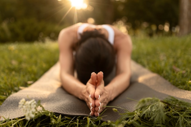 Full shot woman stretching on mat