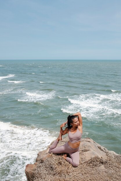 Full shot woman stretching in nature