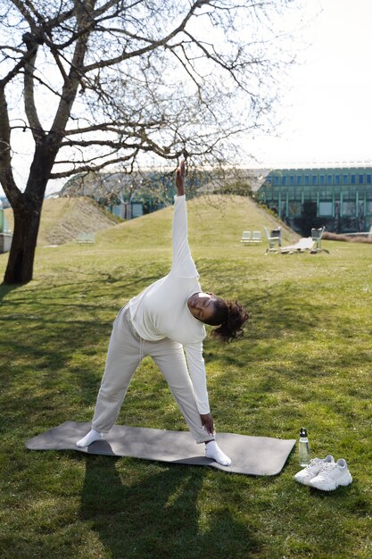 Full shot woman stretching in nature