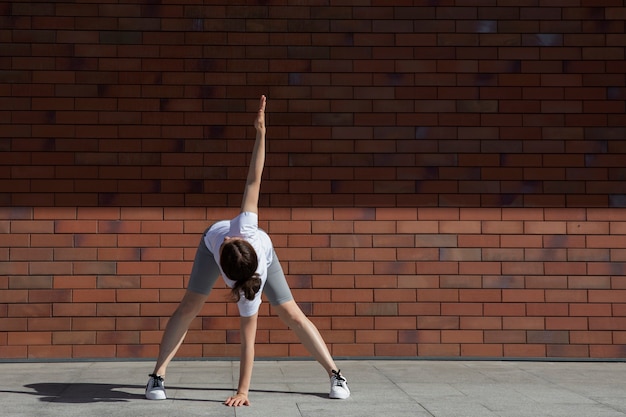 Free photo full shot woman stretching outdoors