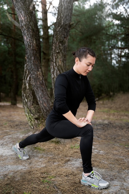 Free photo full shot woman stretching outdoors