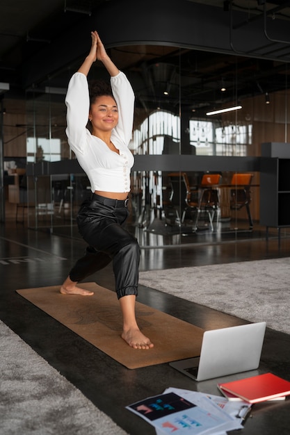 Free photo full shot woman stretching at work