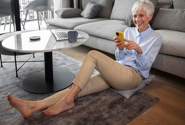 Full shot woman taking a break with smartphone