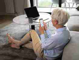 Free photo full shot woman taking a break with smartphone