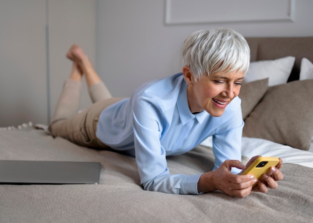 Full shot woman taking a break with smartphone