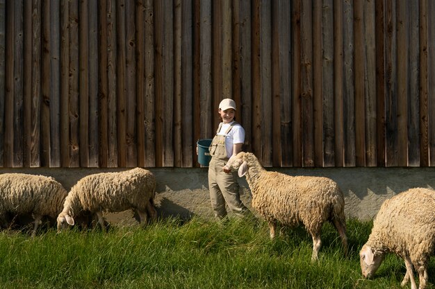 Full shot woman taking care of sheep