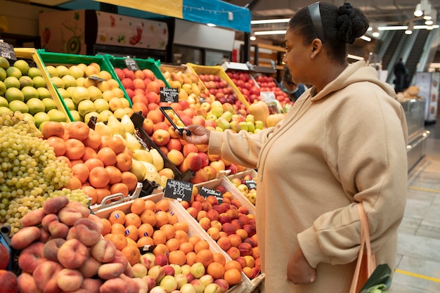 Foto gratuita donna a tutto campo che scatta foto al mercato