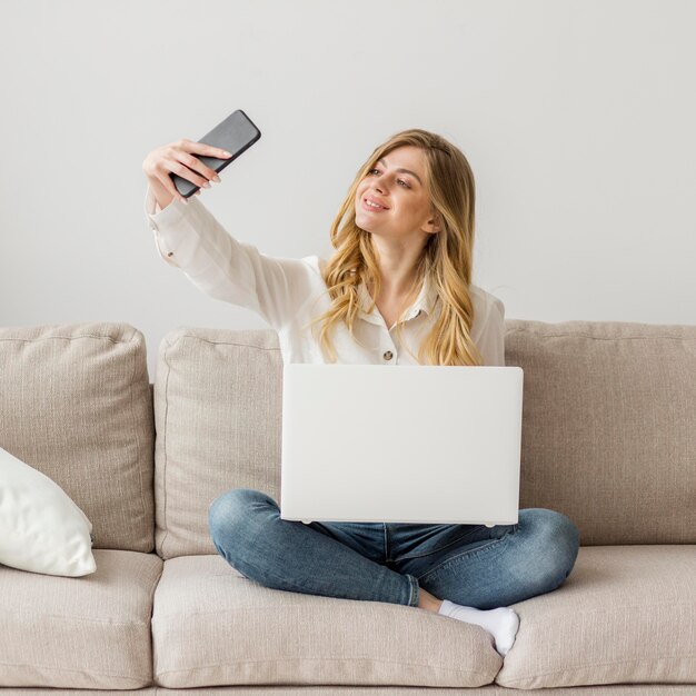 Full shot woman taking selfie