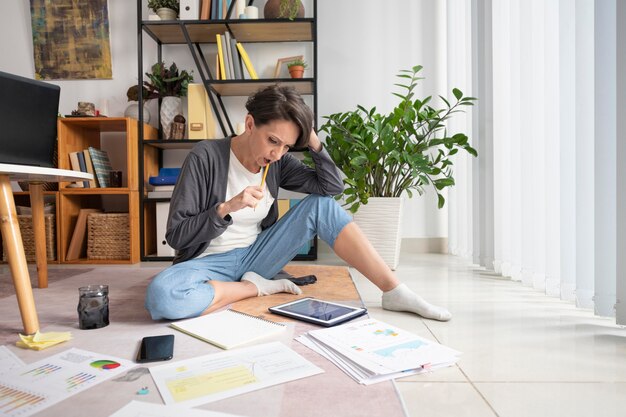 Full shot woman teleworking with tablet