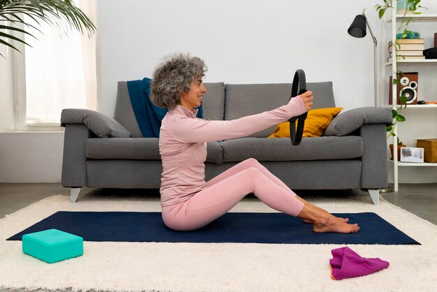 Full shot woman training on mat