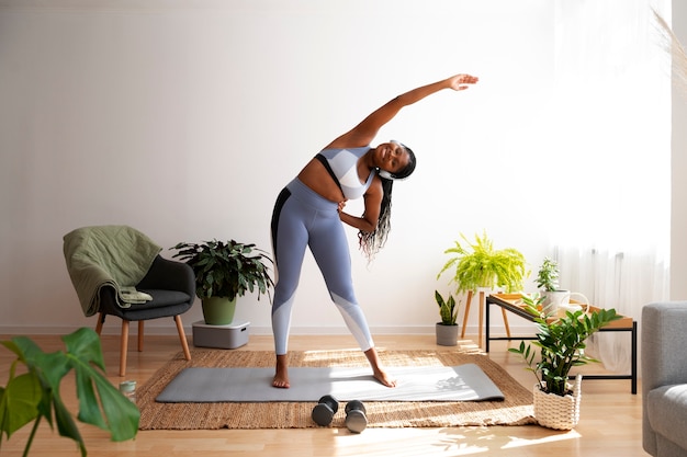 Full shot woman training on mat