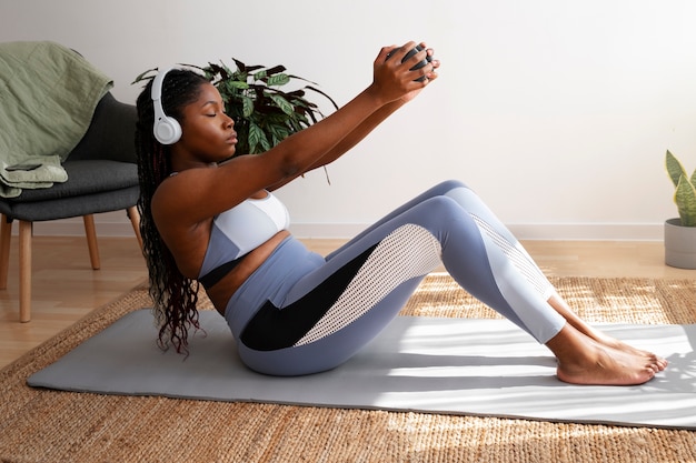 Full shot woman training on mat