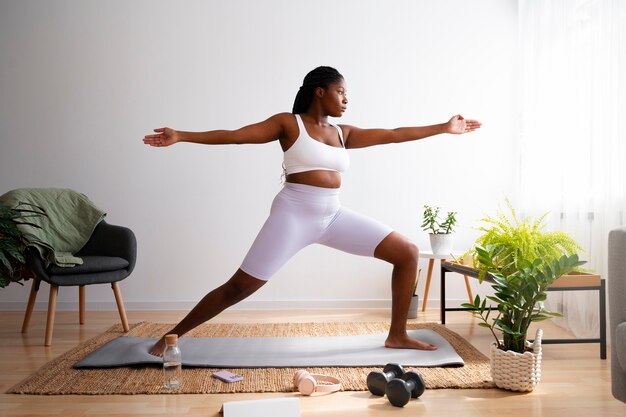 Full shot woman training on mat