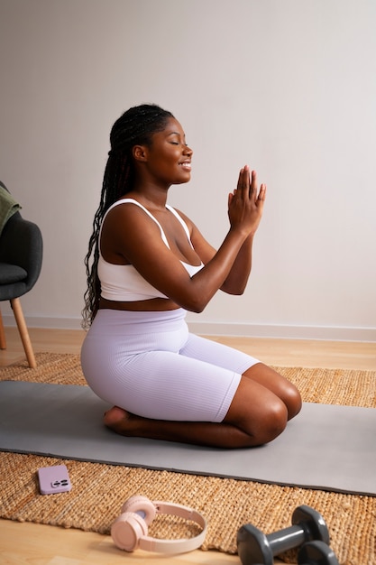 Full shot woman training on mat