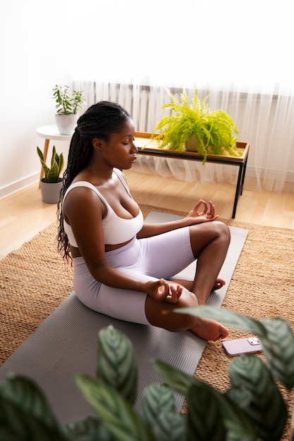 Full shot woman training on mat