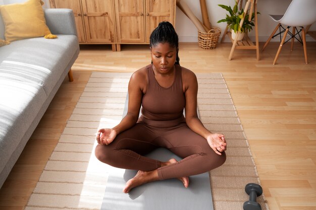 Full shot woman training on mat