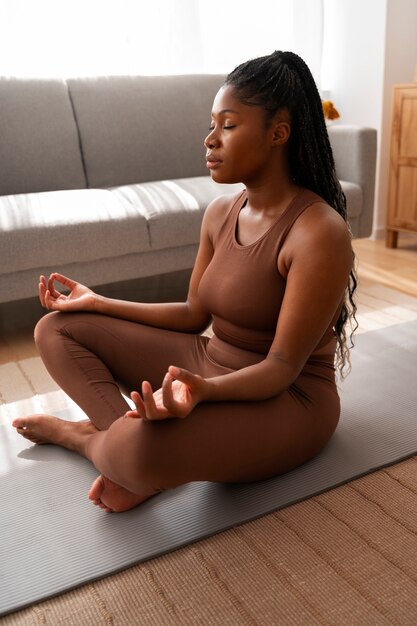 Full shot woman training on mat