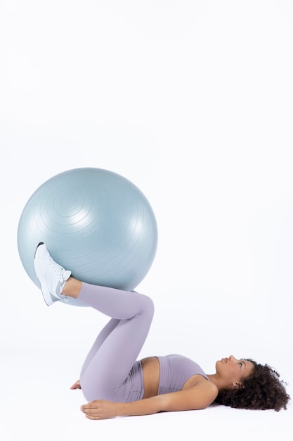 Full shot woman training with gym ball