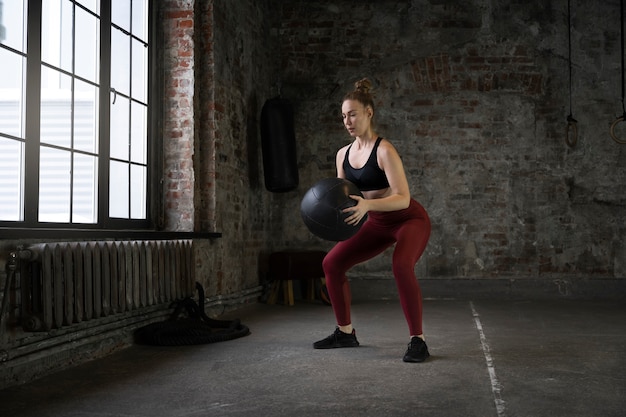 Full shot woman training with gym ball