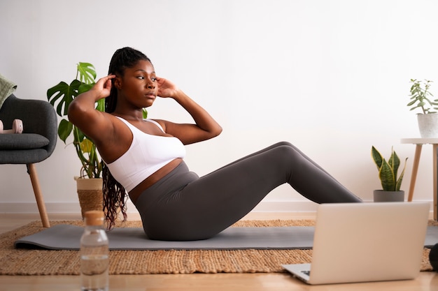 Full shot woman training with laptop