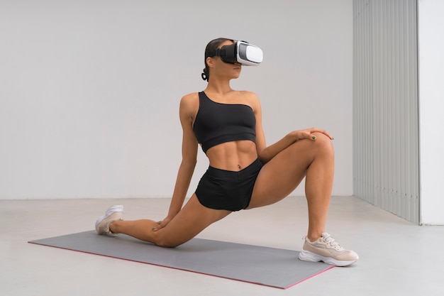 Free photo full shot woman training with vr glasses on