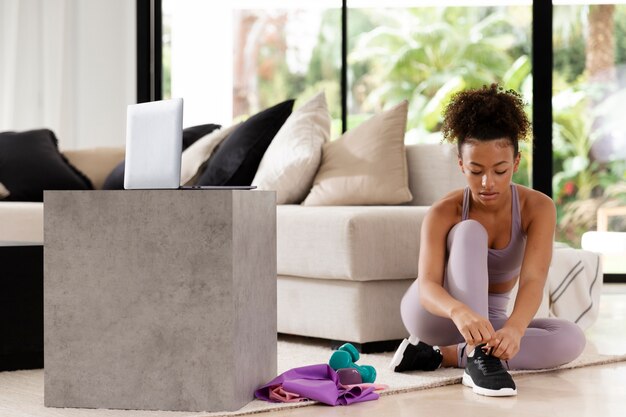 Full shot woman tying shoelaces