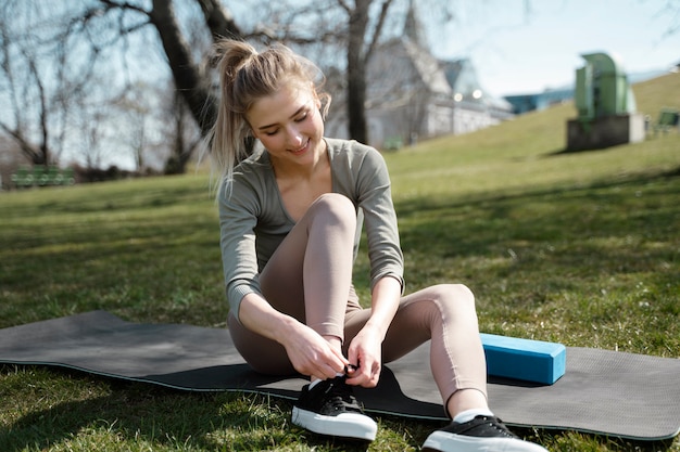 Full shot woman tying shoelaces