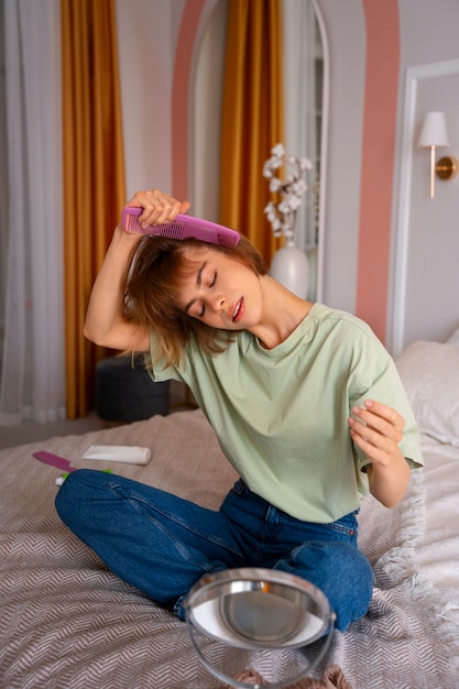 Foto gratuita donna a tutto campo che usa shampoo a secco a casa