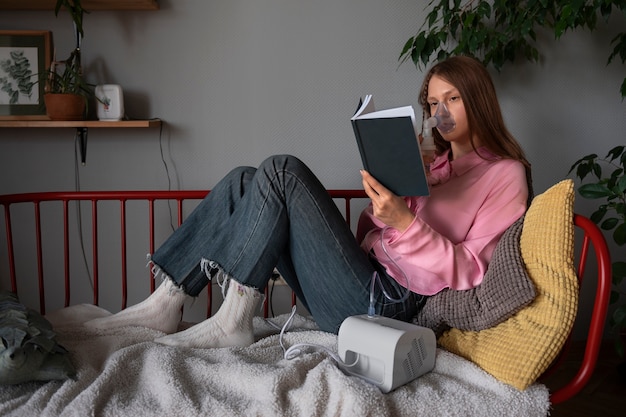 Full shot woman using nebulizer at home