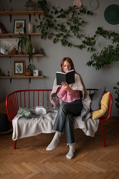 Full shot woman using nebulizer at home