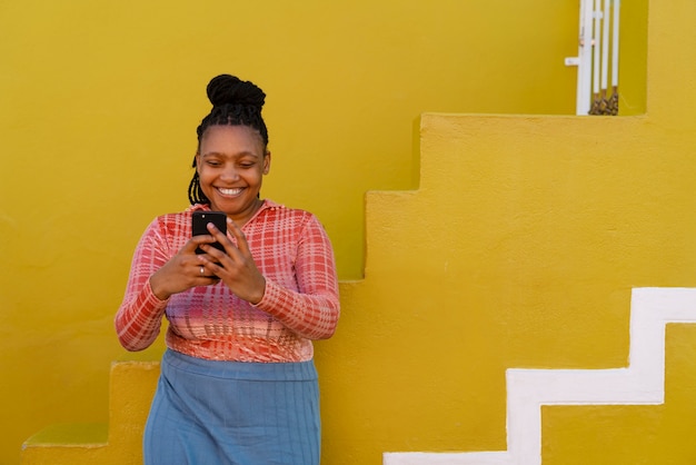 Full shot woman using smartphone outdoors