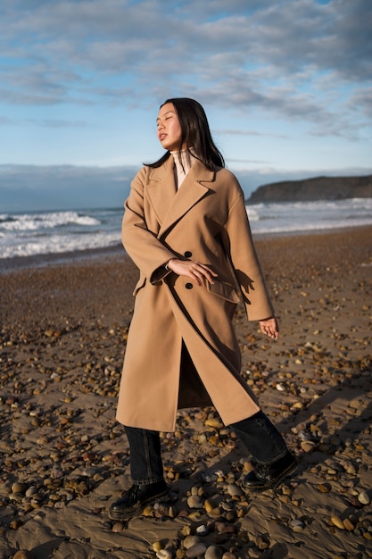 Foto gratuita donna piena del colpo che cammina sulla spiaggia