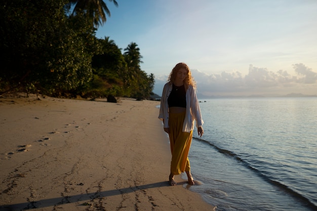 Free photo full shot woman walking on beach