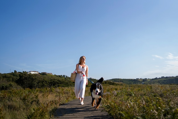 Free photo full shot woman walking dog